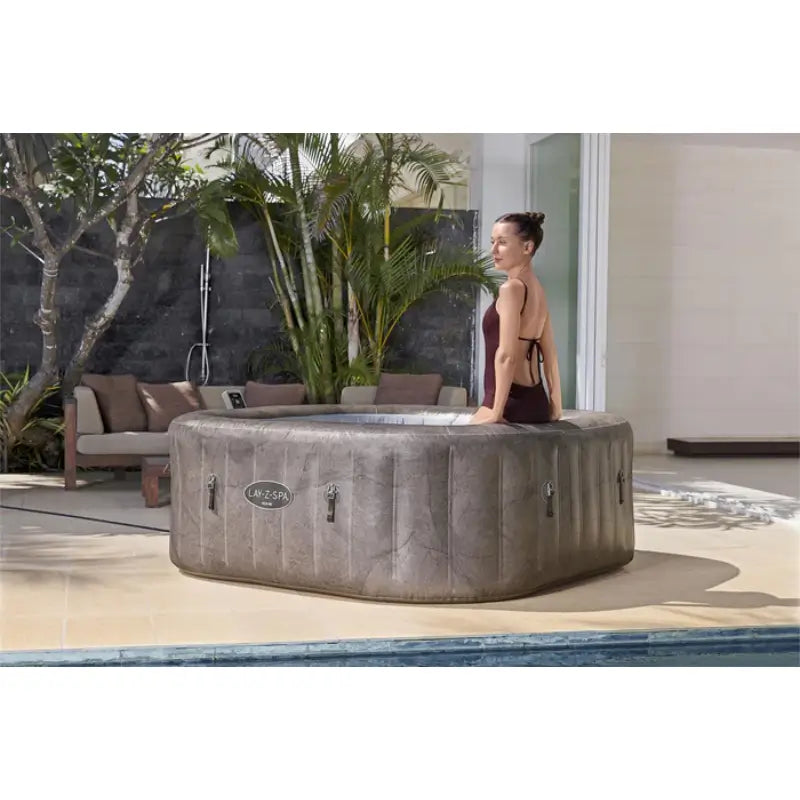 neutral-marble-effect-lazy-spa-rome-hot-tub-with-woman-sitting-on-rim