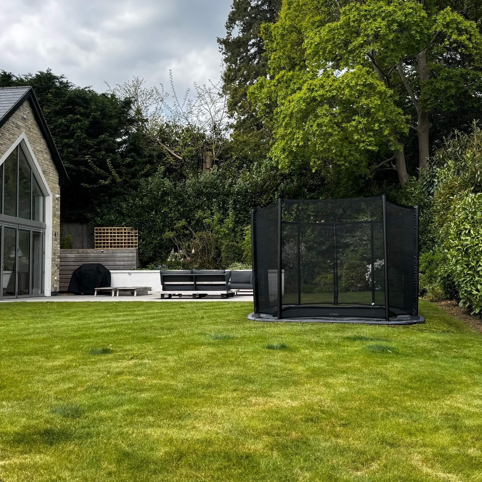 north-15ft-x-10ft-rectangular-trampoline-with-enclosure-on-lawn-beside-house