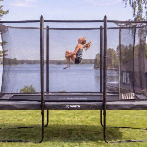 north-pioneer-12ft-x-8ft-rectangular-trampoline-with-child-jumping-in-lakeside-garden