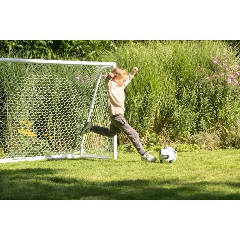 Kids kicking football ball in front of EXIT Scala outdoor football goal.