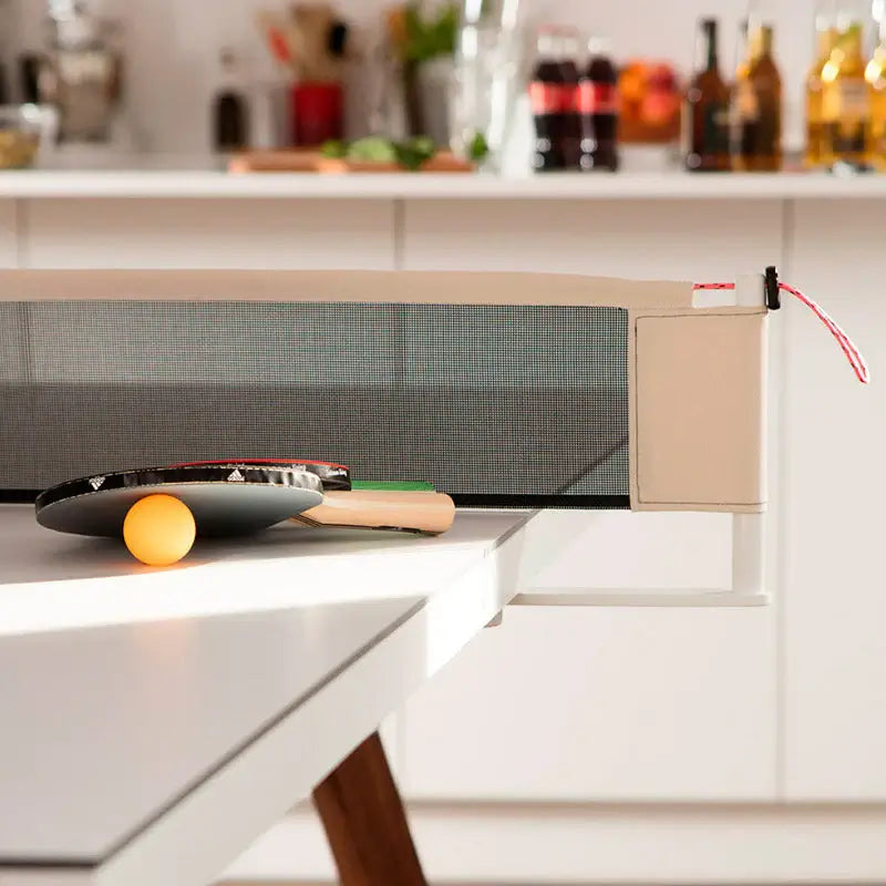outdoor-rs-barcelona-you-and-me-ping-pong-table-net-detail-with-paddle-and-ball-on-the-board-and-drinks-in-the-background