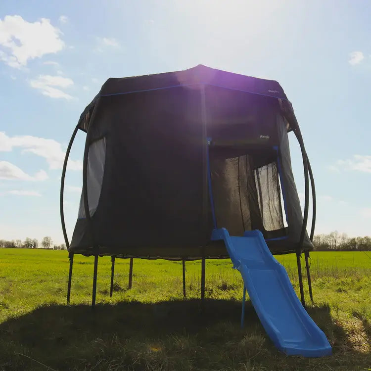 outdoor-trampoline-with-enclosure-tent-and-blue-slide-in-sunny-field