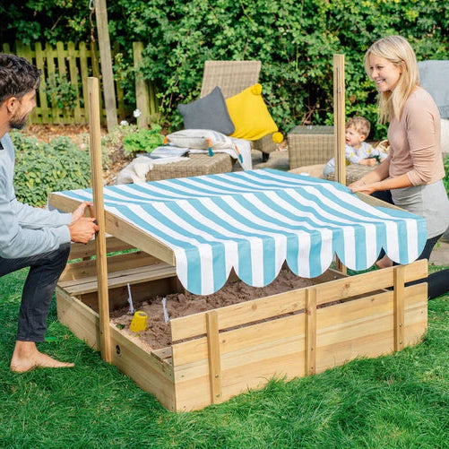 parents-setting-up-striped-sunshade-over-backyard-sandpit