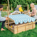 parents-setting-up-striped-sunshade-over-backyard-sandpit