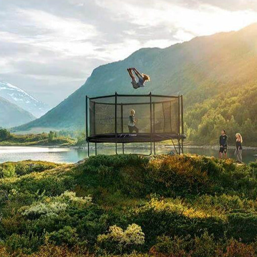 person-flipping-on-north-legend-oval-trampoline-in-mountain-landscape