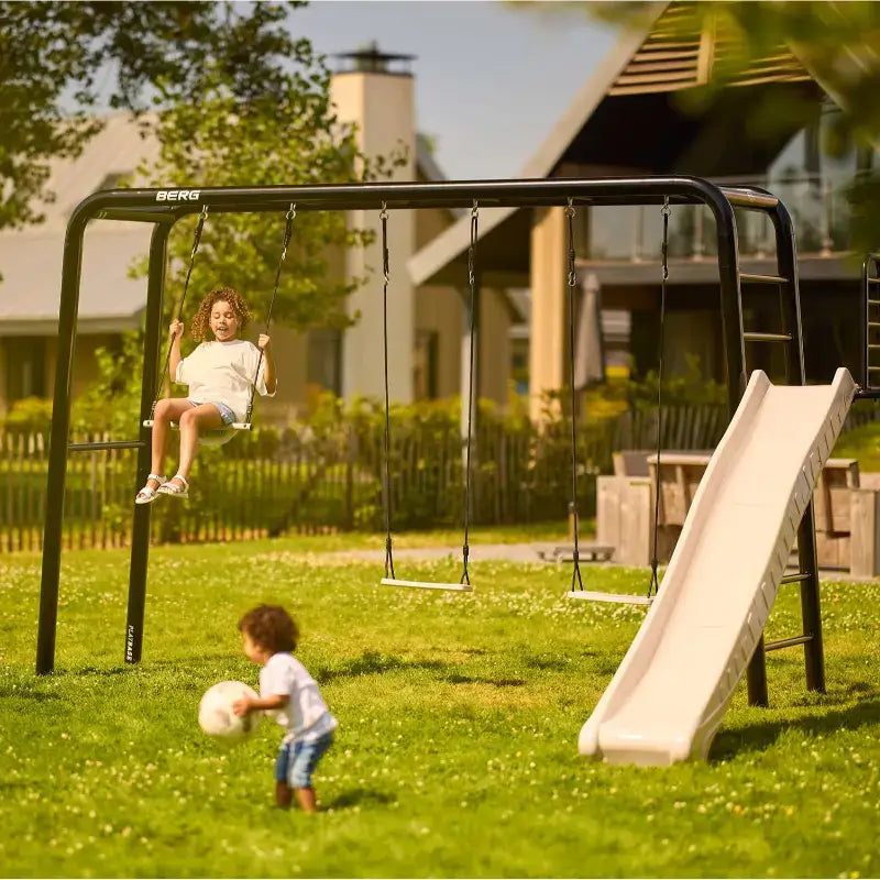 children-playing-on-platform-and-slide-on-berg-playbase-large-with-swings-frontyard-setup