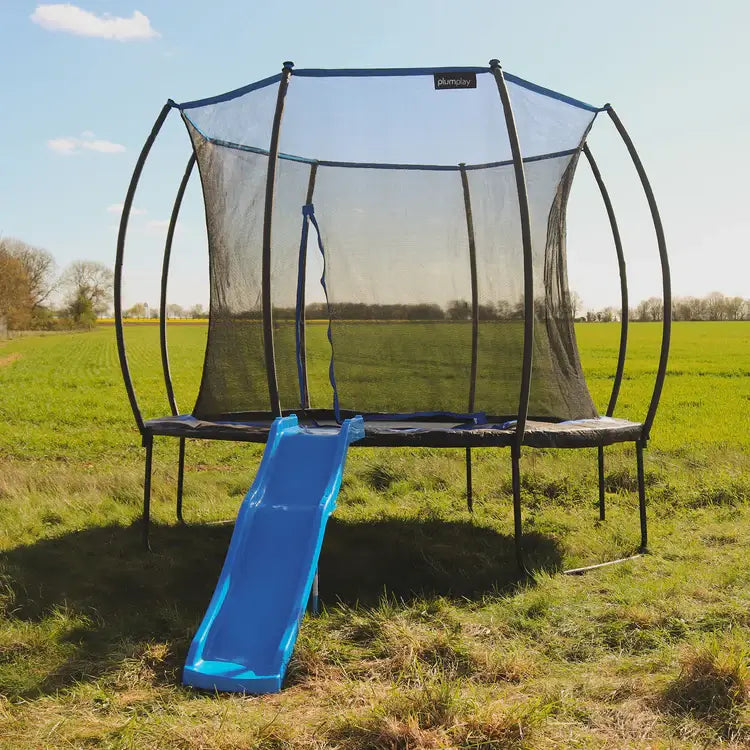 round-outdoor-trampoline-with-blue-slide-front-view-in-field