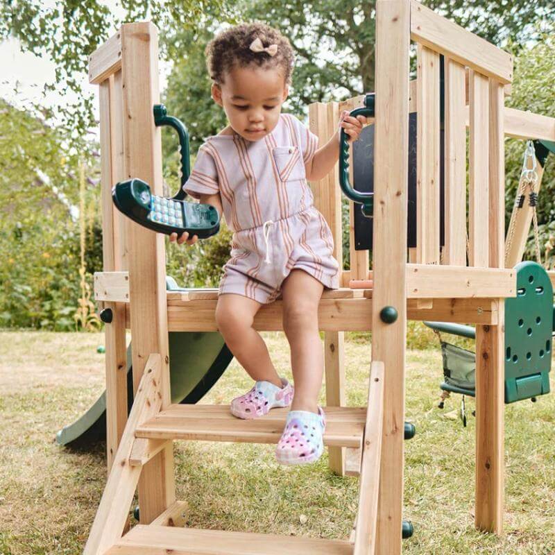 toddler-climbing-down-wooden-playcentre-steps-holding-toy-telephone