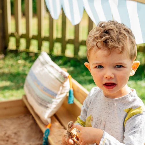 toddler-playing-in-covered-wooden-sandbox-with-cushion-seat