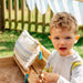 toddler-playing-in-covered-wooden-sandbox-with-cushion-seat