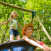 two-children-laughing-and-playing-together-on-a-plum-spider-monkey-wooden-swing-set-in-a-sunny-garden