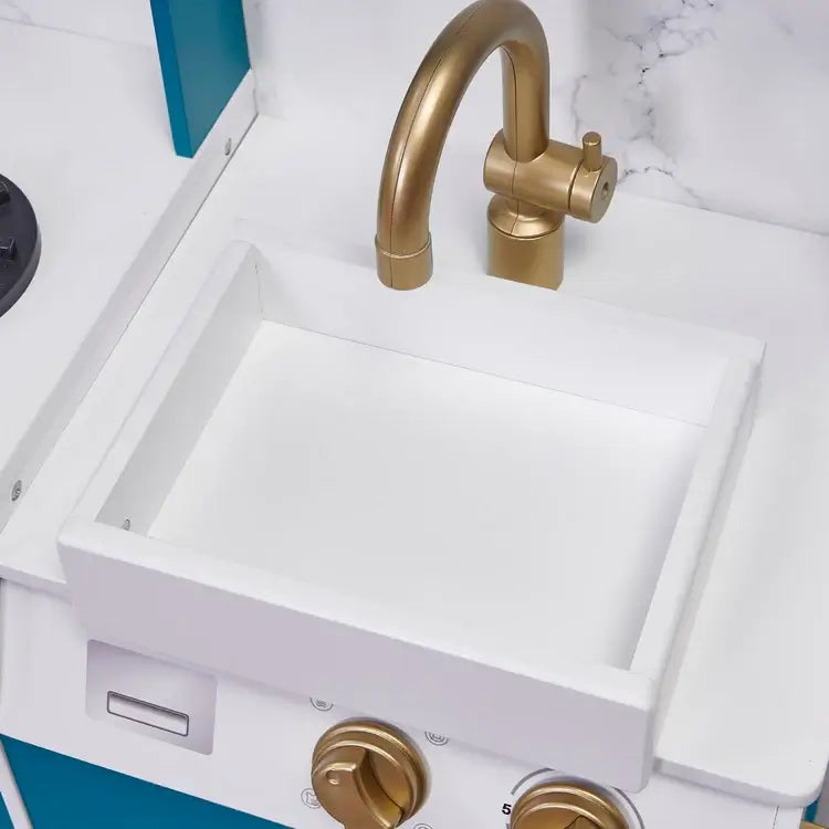 white-play-sink-with-brushed-gold-tap-detail