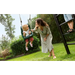 woman-pushing-young-child-in-green-bucket-swing-on-outdoor-play-frame-in-garden