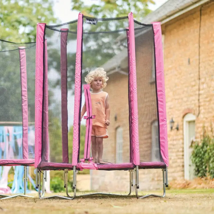 young-child-standing-inside-pink-enclosed-trampoline